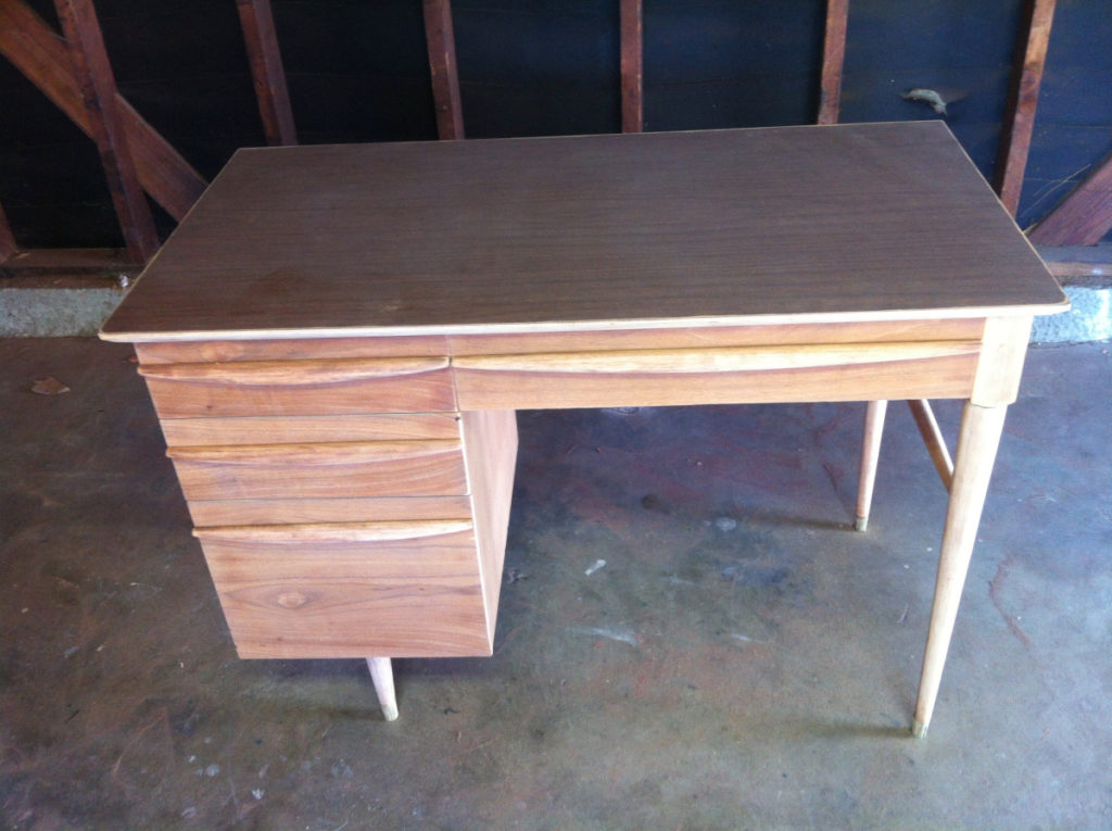 Naked teak desk in a garage